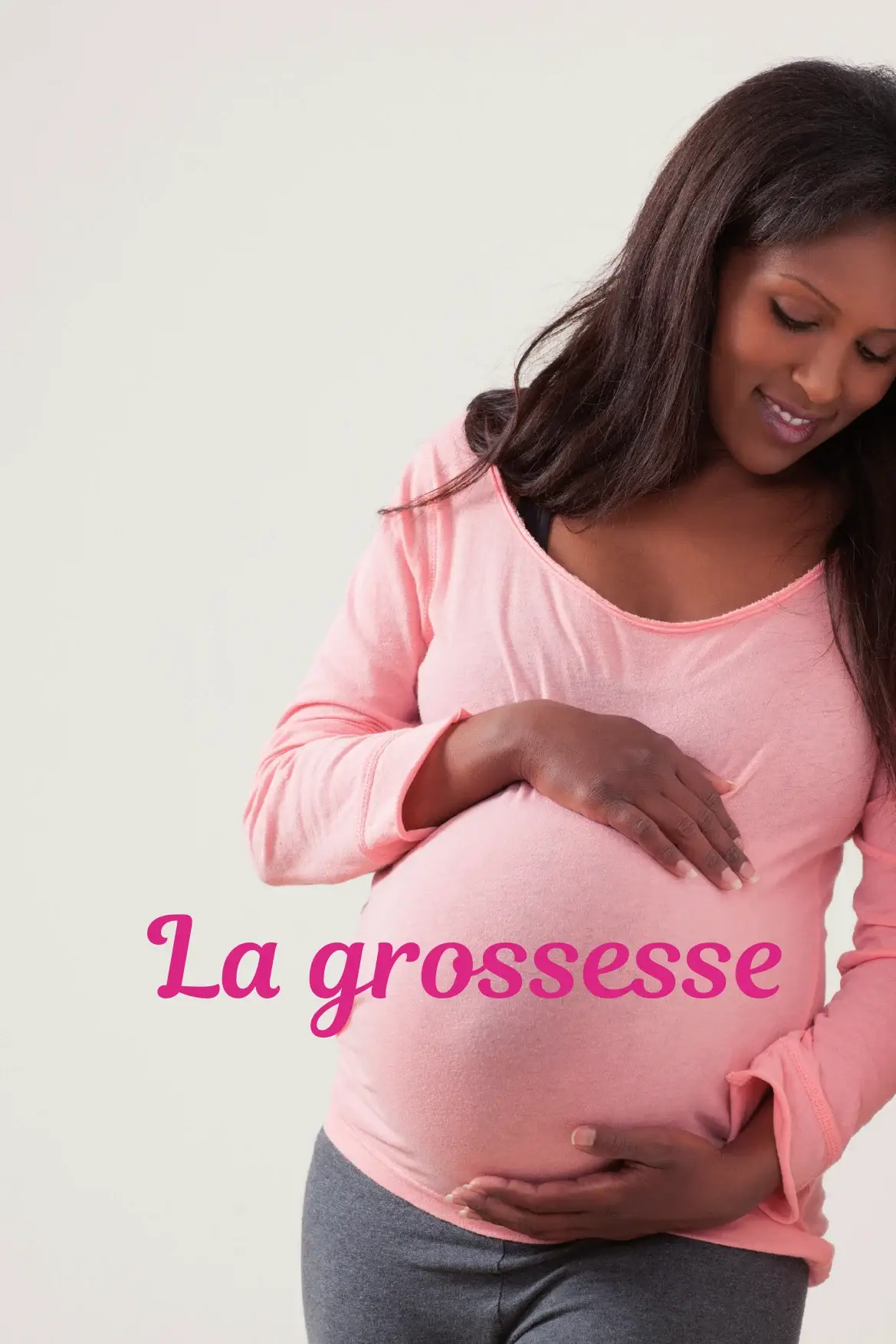 Femme enceinte souriante en chandail rose tenant son ventre à deux mains, titre « La grossesse »